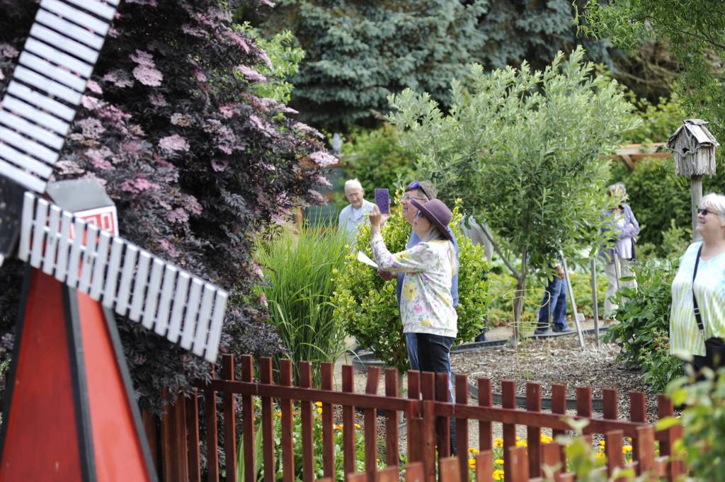 Sequim Gazette photo by Matthew Nash/ Participants in the Petals Pathways Home Garden Tour traverse through the Harvest Haven/JR Farmstand on June 28.