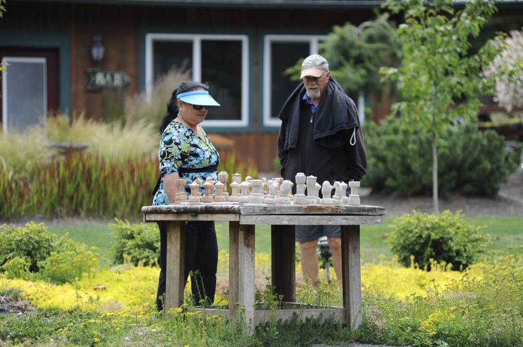 Sequim Gazette photo by Matthew Nash
Char and Steve Reeves of Sequim admire an outdoor chess set at Second Chance Ranch during the Petals & Pathways Home Garden Tour on June 28. Steve said they attend the tour at different locations each year.