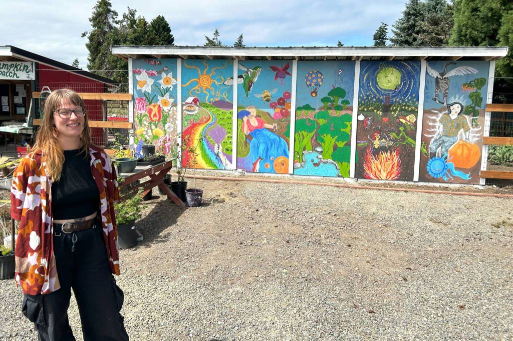 Sequim Gazette photo by Matthew Nash/ Emily Webb finished the Harvest Haven/J&R Farmstand mural the morning of June 28, a few hours before the start of the Petals & Pathways Home Garden Tour. Webb started the mural in April and worked on it a few times a week as weather allowed and calls it a love letter to Sequim.