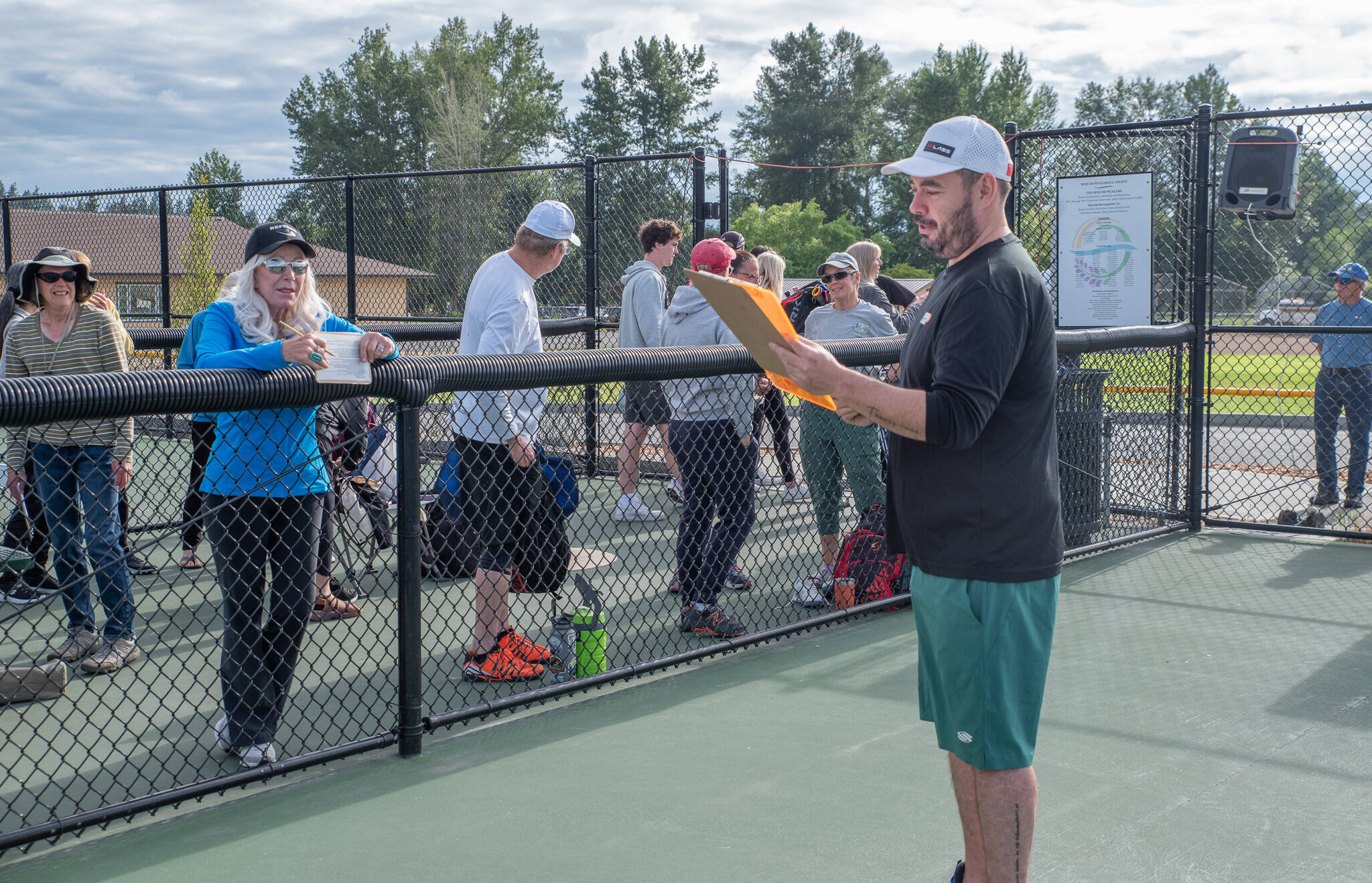 Photo by Emily Matthiessen
Pablo Garnados, minor league pickleball NW director, explains the rules of the Sequim Fling pickleball tournament on Saturday at Carrie Blake Community Park in Sequim. Hosted by the Sequim Picklers, which has almost 500 members, the Friday through Sunday tournament was the first time the club has held a minor league tournament. Granados said that he loves the fact that I can bring it out here. Saturdays opening ceremony included the Grand Olympics Chorus singing the national anthem and a tribute to Marty Hoffman.