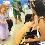 Sequim Gazette photo by Matthew Nash/ Three-year-old Aubrey Roberts and her grandmother, Beth Hancock of Sequim, admire the dresses of Sequim Irrigation Festivals Queen Lily Tjemsland and Princess Joanna Morales on July 1 during Storytime with the Royal Court.