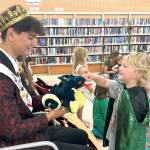 Sequim Gazette photo by Matthew Nash/ James Lynn, 3, dressed as a dragon, talks with Sequim Irrigation Festival Prince Malachi Byrne about dragons after Storytime with the Royal Court. James father Pat said it was his familys first time at Storytime with the North Olympic Library System and hes known Malachi since he was a little boy.