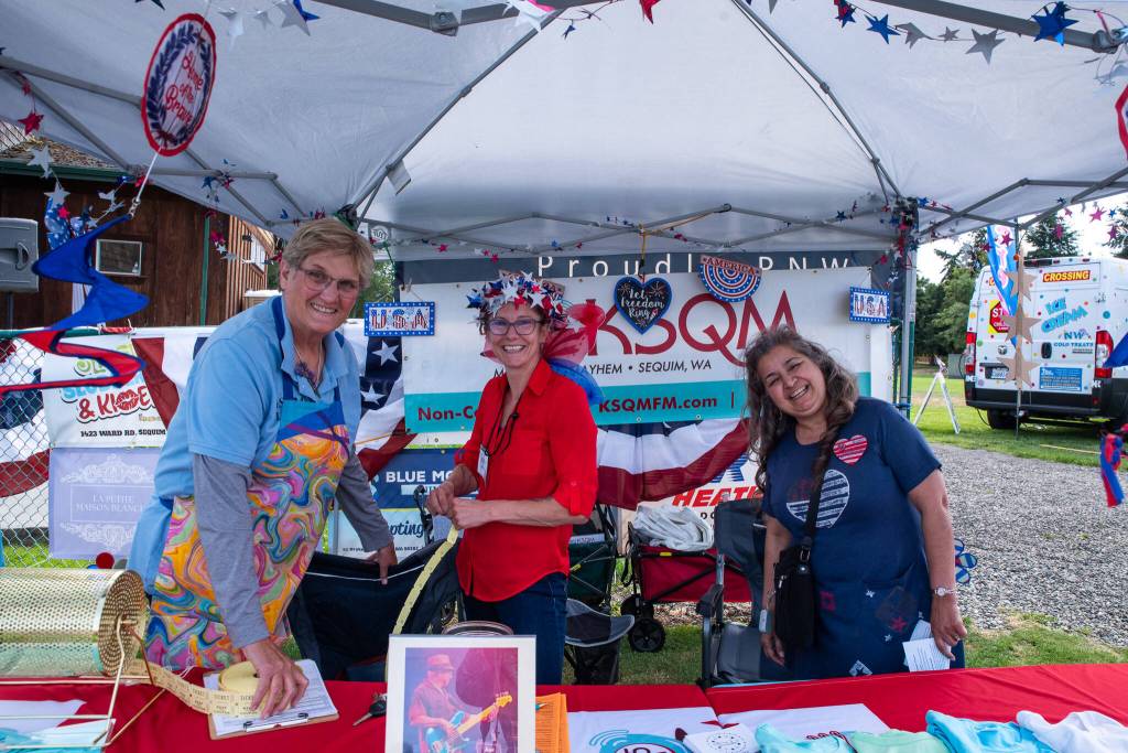 Sequim Gazette Photo by Emily Matthiessen/ Susan Sorensen, Jenniifer Pettit and Mirriam Childers of KSQM 91.5, Sequims radio station, sell raffle tickets during the Sequim City Bands Independence Day performance.