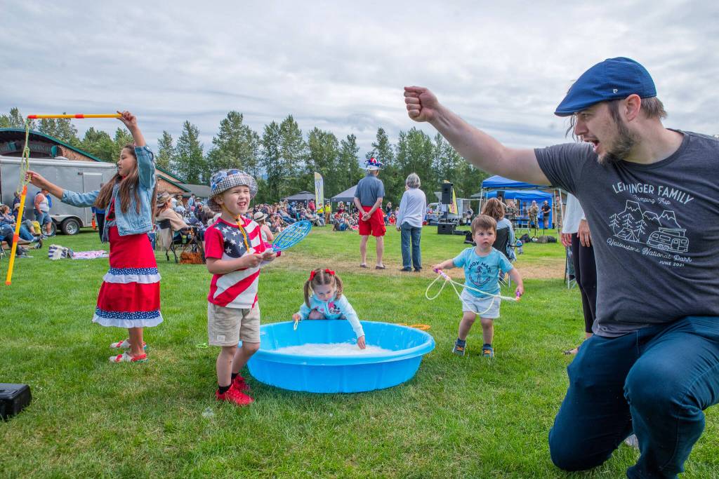 Sequim Gazette photo by Emily Matthiessen/ Shane Leininger plays with his son Ronan, 4, in the hat, alongside, from left to right, Madison Casteel, 7, Olivia Dyer, 4 and Leon Dyer, 2, during Sequim Citys Independence Day celebration at Carrie Blake Community Park.