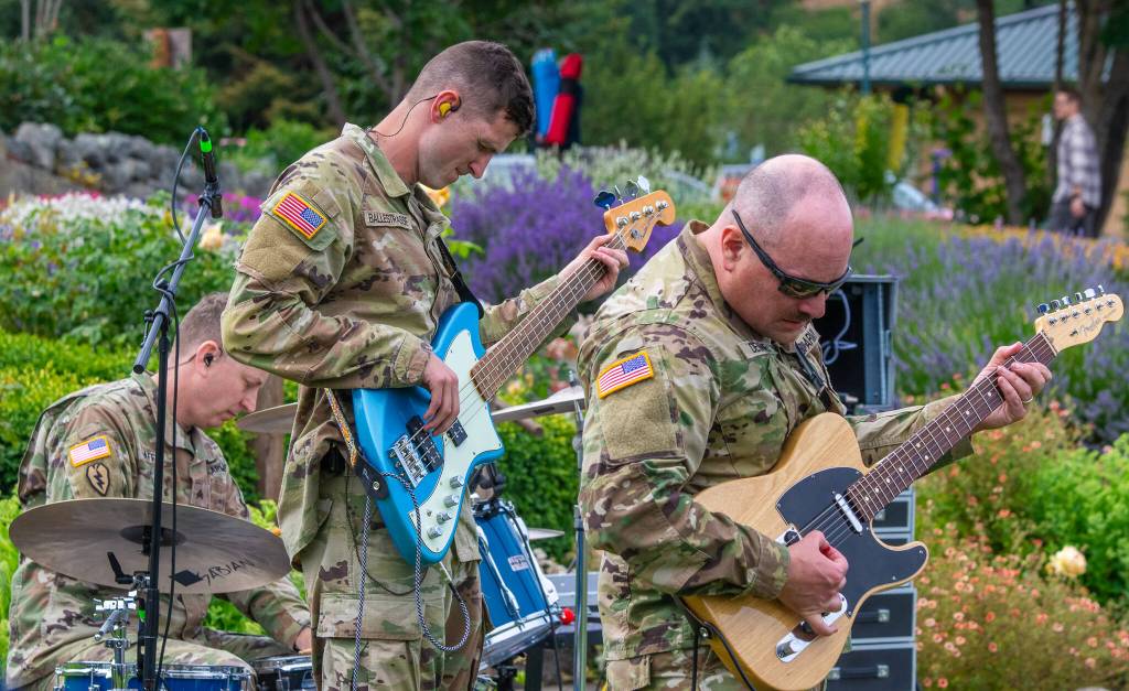 Sequim Gazette photo by Emily Matthiessen/ Drummer Marcus Jaffe, bass player Joseph Ballestrasse and guitarist Glenn Devage rock out during the 133d Washington Army National Guard Bands performance on Friday at the City of Sequims Independence Day celebration in Carrie Blake Community Park.