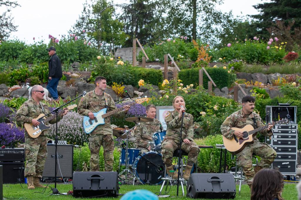 Sequim Gazette photo by Emily Matthiessen/ At Carrie Blakes Botanical Terrace Garden, the 133d Washington Army National Guard Band, from Camp Murray performs rock and pop music for an appreciative crowd during Sequim Citys Independence Day celebration. From left to right: Glenn Devage, Joseph Ballestrasse, Marcus Jaffe, Tricia Scheer and Bradley Patton.