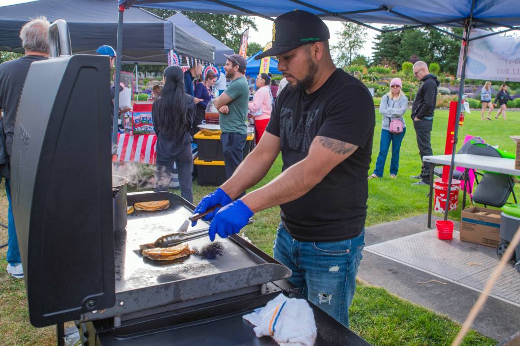Sequim Gazette photo by Emily Matthiessen/ Francisco Hernandez grills tacos in the Paradise Cafes stall at Carrie Blake Community Parks Independence Day celebration on Friday.