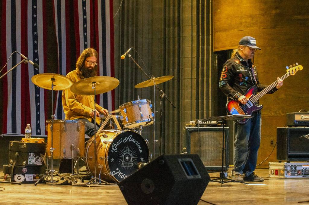 Sequim Gazette photo by Emily Matthiessen/ Great American Trainwrecks Dave Bush and Joe Cable glow golden in the light of the James Center Bandshell at dusk as Independence Day turns to night.