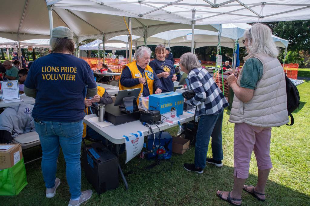 Sequim Gazette photo by Emily Matthiessen/ People congregate at the purchase line of the 12th Annual Crab Feed in Sequims Pioneer Memorial Park on June 28.