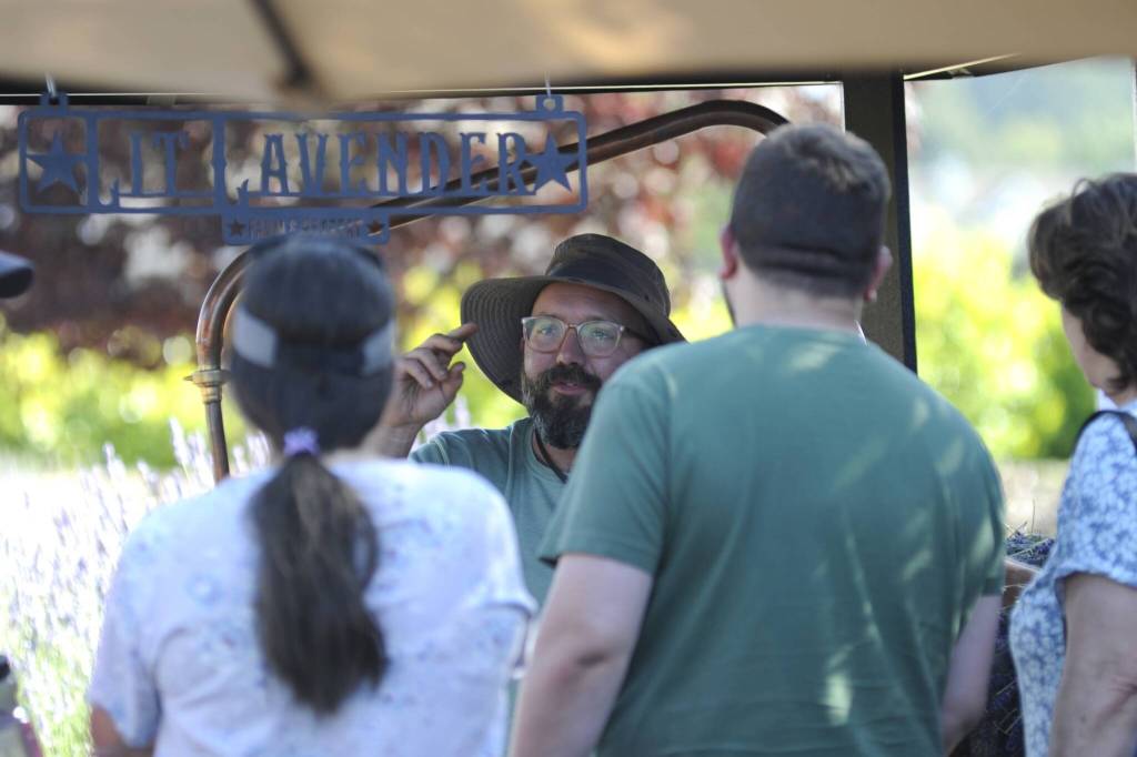 Sequim Gazette photo by Matthew Nash/ Joe Regalia with Lit Lavender discusses the lavender oil distillation process with visitors during the Sequim Lavender Weekend.