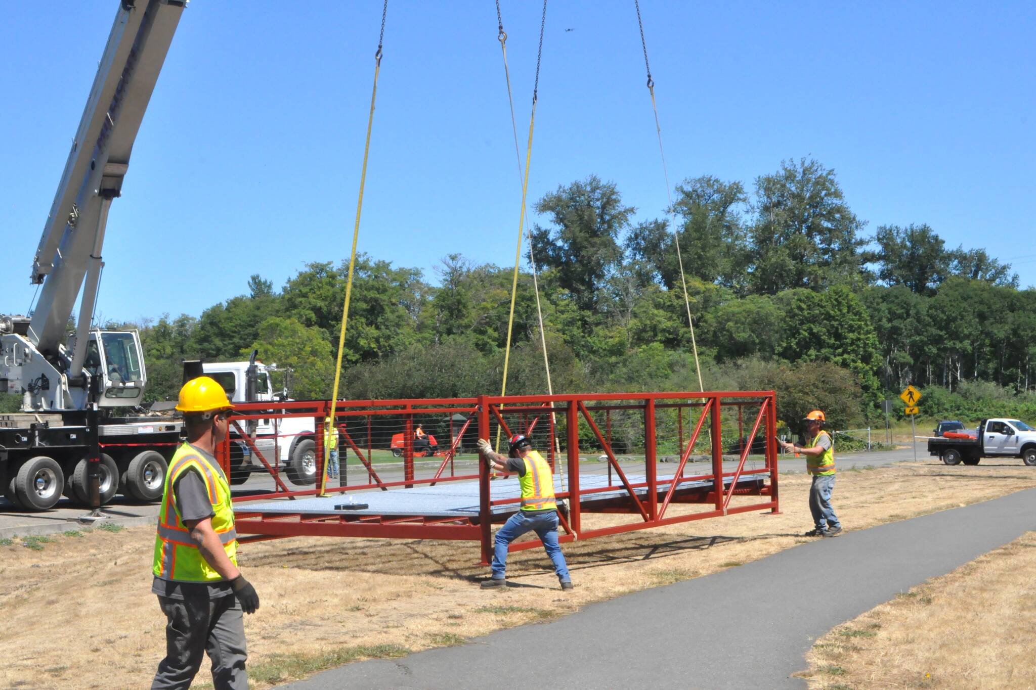 Sequim Gazette photos by Matthew Nash
City staff help navigate one of two new pedestrian bridges delivered to Carrie Blake Community Park.