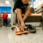 Sequim Gazette photo by Jacques Star/ Reindel Harrison tries on a pair of Jordans. The boy was among other local students who received $100 gift cards to buy new shoes for school. Any money left over could be used for socks or other items other than candy or toys.