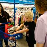 Sequim Gazette photo by Jacques Star 
Reindel Harrison places the shoes he selected in a shopping cart pushed by his mother, Kat Malcom, as H.U.M.A.N. board member Mary Daniel looks on during the Saturday, Aug. 2 shopping trip at Ross Dress for Less that was part of the nonprofits Shoes for Souls campaign. H.U.M.A.N. - Having Understanding Means Acting Now - was founded by Darrin and Alicia Liggins of Sequim.