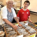 Photo by Judy Newblom/ Stamp collector Vera Felts and her grandson Hudson Pelly look through collections at the 2024 Strait Stamp Show. It returns Saturday, Aug. 9 to the Guy Cole Event Center.