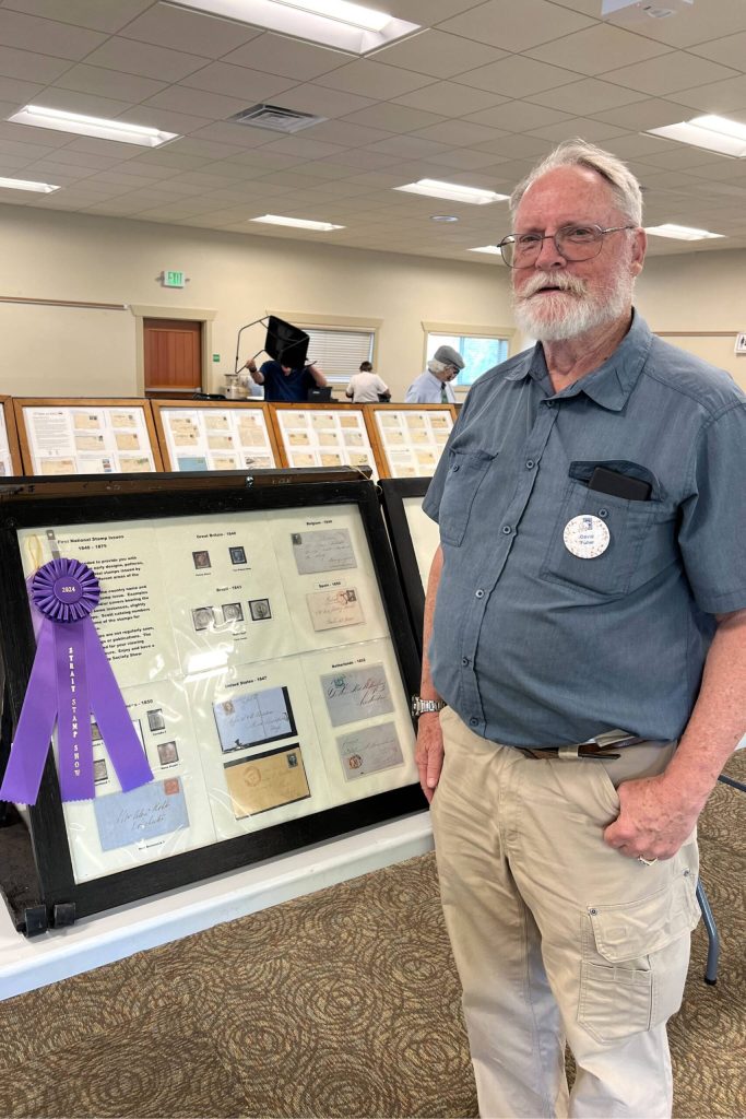 Photo by Judy Newblom/ Dave Fuller stands with his exhibit at the 2024 Strait Stamp Show. This years show on Aug. 9 features several new and returning displays, collections, and vendors.