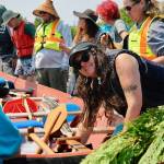 Sequim Gazette photo by Jacques Star/ Dezi Rose of the Jamestown SKlallam Tribe secures a canoe on the beach and discusses the journey with her fellow tribal members.