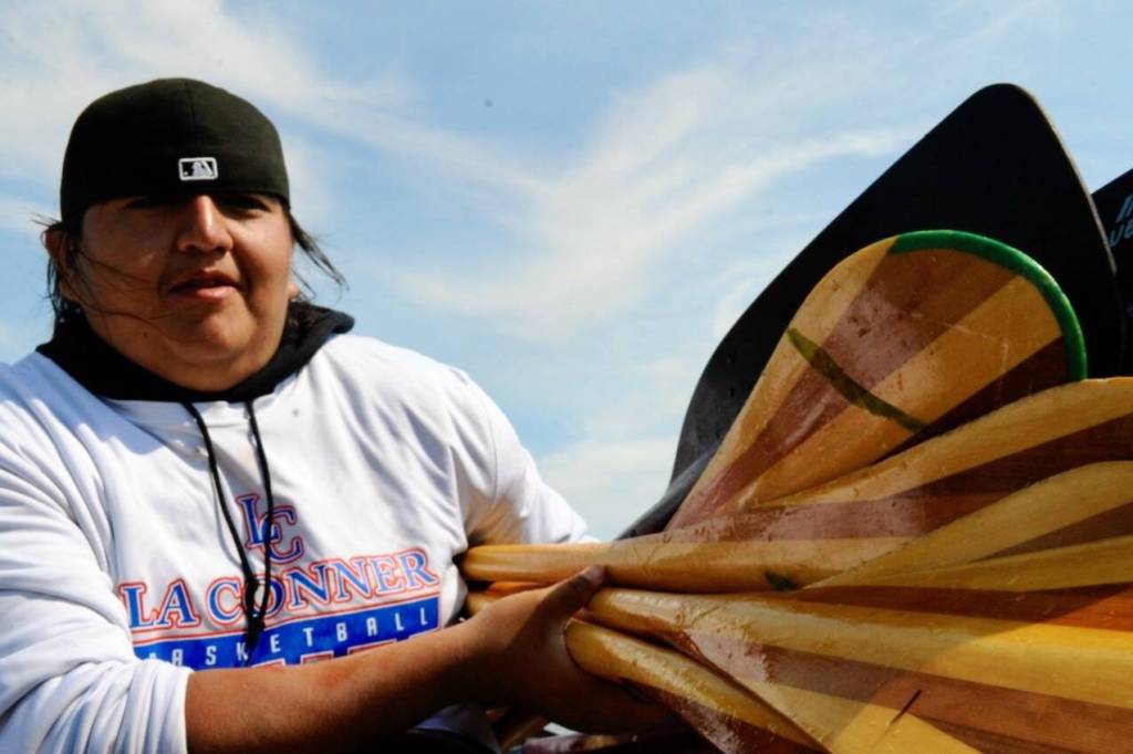 Sequim Gazette photo by Jacques Star/ Chas James of the Swinomish Tribe carries handmade paddles ashore.