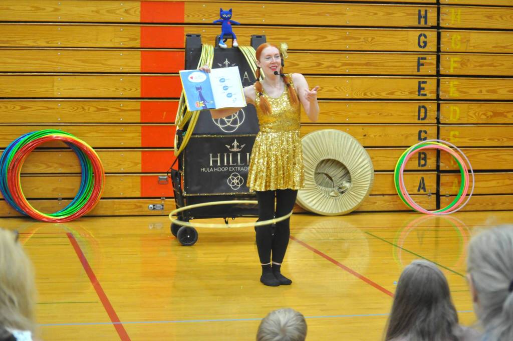 Sequim Gazette photo by Matthew Nash/ While hula hooping, Hillia Hula reads Pete The Cat: I Love My White Shoes to a crowd at the Sequim Librarys Summer Reading Program.