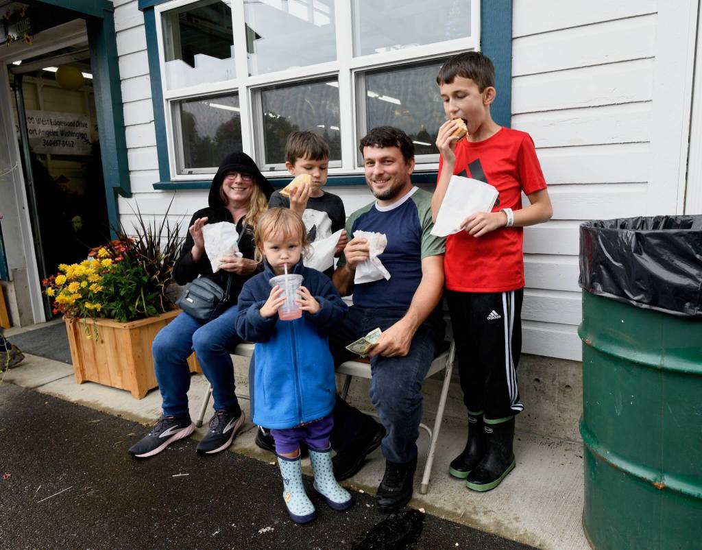 Dad David Turner and grandmother Suzie Johnson along with youngsters Joseph Turner (red shirt), Max Turner (gray shirt) and Katie Turner take a break to refuel after enjoying rides at the Clallam County Fair.