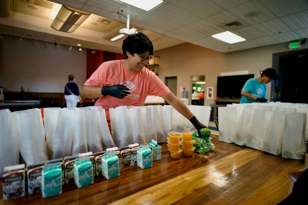 Teen workers and Boys & Girls Club staff make sure lunch sacks are filled with nutritious items.