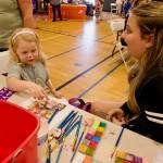 Sequim High School Cheerleader Riley Campbell (left) helps Addy Galloway (left) pick out a face paint character.
