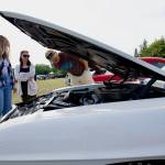 Craig Wernsing from Port Angeles looks under the hood of a Pontiac Firebird while Kristina Shepherd, left, and Audrey Wernsing look on.