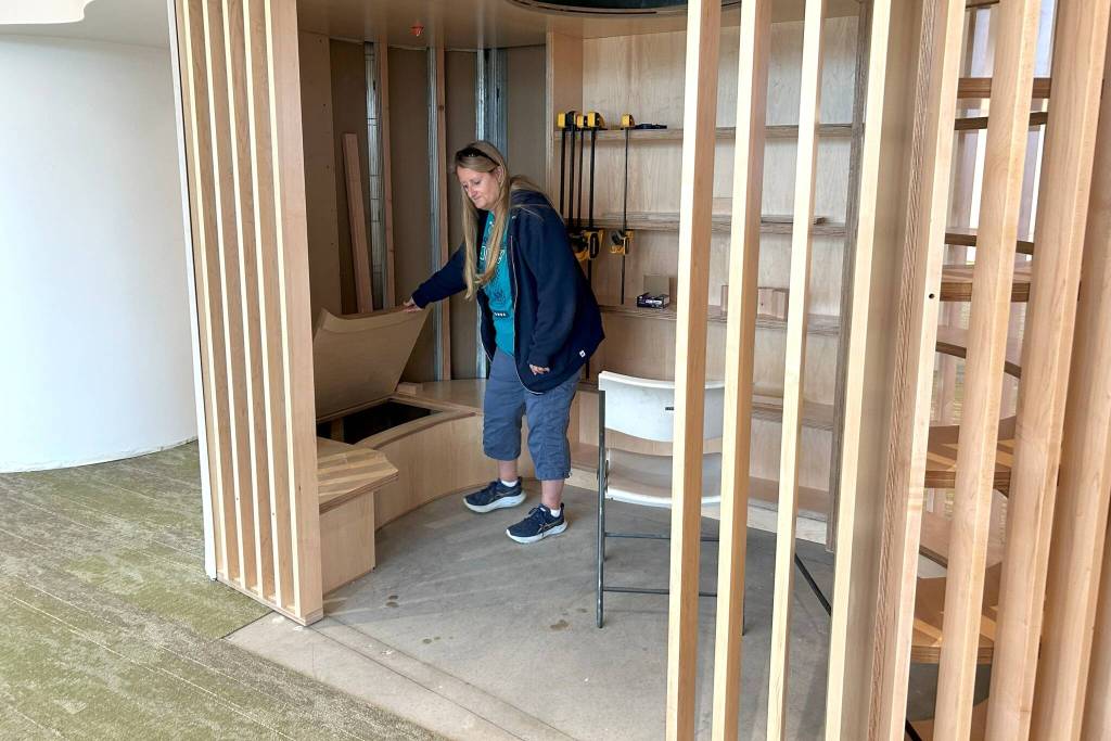 Sequim Gazette photo by Matthew Nash/ Jennifer Pelikan, a NOLS trustee representative from the West End, takes a peek inside a book nook of the Sequim Librarys childrens area.
