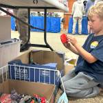 Azrael Diamond, 5, of Sequim looks through boxes of toys at the Olympic Peninsula Toy and Collectibles Show. He attended with his mom and grandmothers, with one of them saying Azrael is down for any toys.