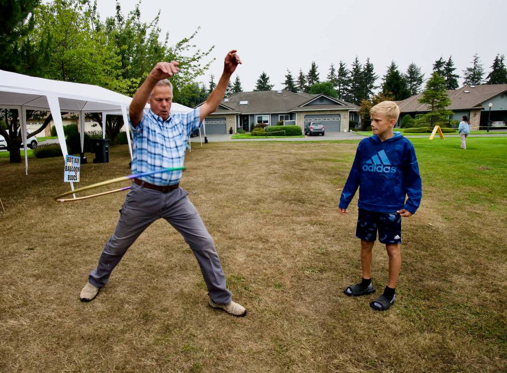 John Buchser, left, tries to win the Hula Hoop contest at Saturdays picnic for the Sunland community as Caden Dyck, right, eyes his moves. The winner was entered into a drawing for a free round of golf at Sunland Golf Course.