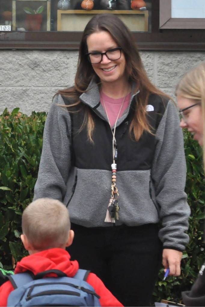 Sequim Gazette photo by Matthew Nash/ Kindergarten teacher Stephanie OMera greets some of her students who were dropped off before the first day of school.