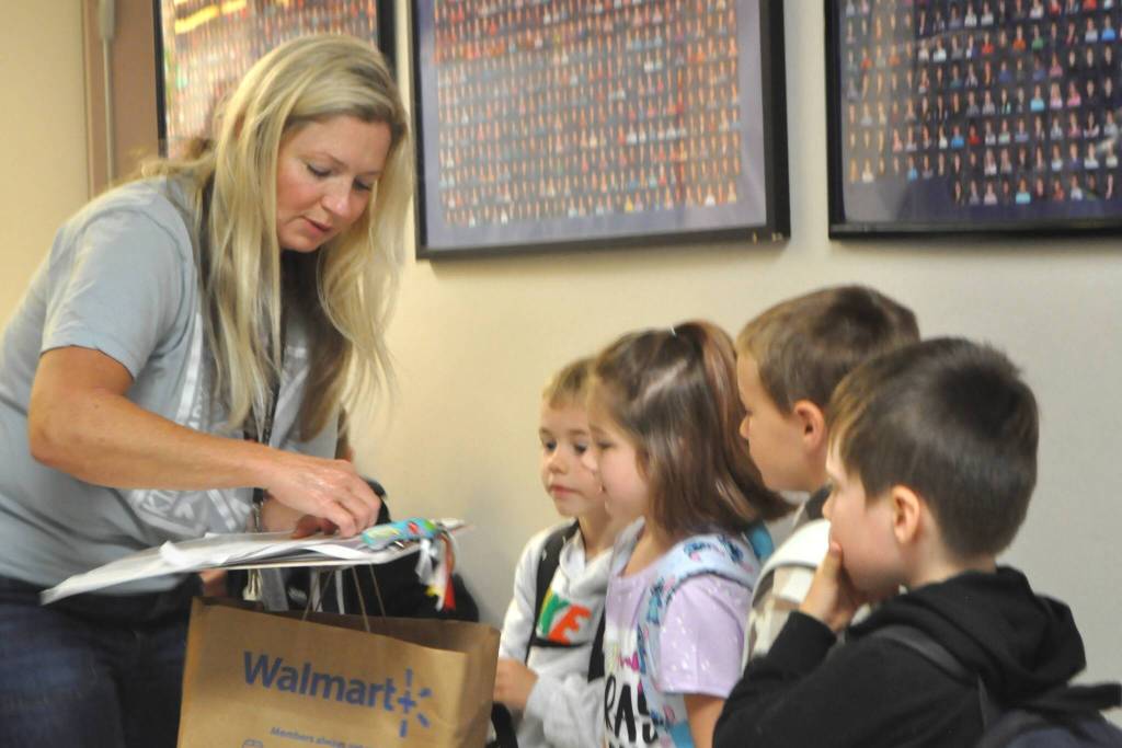 Sequim Gazette photo by Matthew Nash/ Greywolf Elementary kindergarten teacher Sarah Wilhelm checks in some of her kindergarten students on the first day of school.