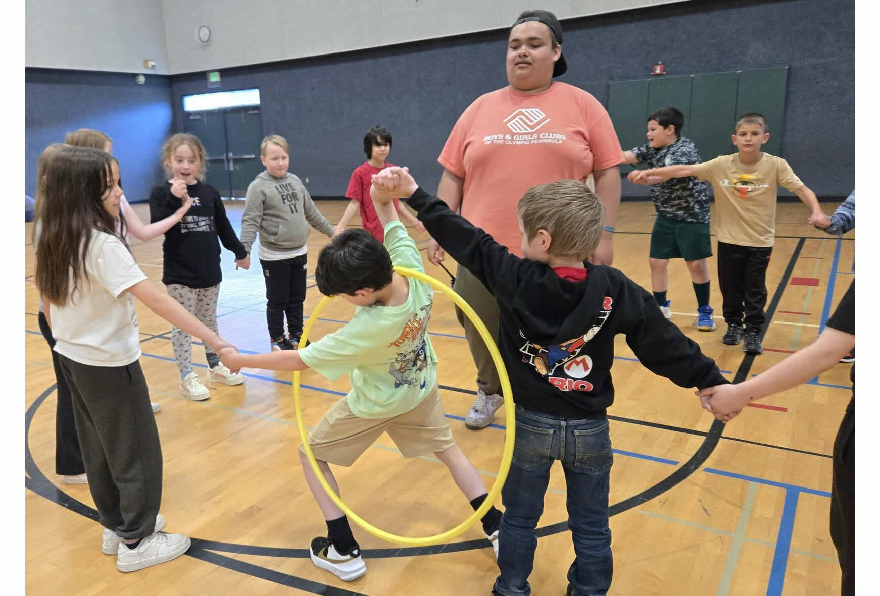 Photo courtesy of the Boys & Girls Clubs of the Olympic Peninsula
Youth Development staffer Aymon Anderson leads a group of elementary school children in a hula hoop challenge as part of the Sequim Boys & Girls Clubs Project L.A.N.E.