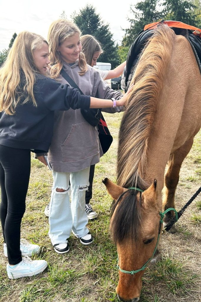 Sequim Gazette photo by Matthew Nash/ Fifth graders Olivia Wright and Aurora Pace pet Jack the horse with the Back Country Horsemen of Washington Peninsula Chapter.