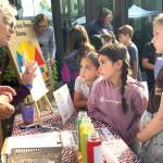 Cathy Lear, a volunteer with the Clallam County League of Women Voters, speaks with third graders, from left, Romina Gonzalez-Tapia, Allison Washburn, and Maci Dailey about ways they can conserve water during the Dungeness River Festival.