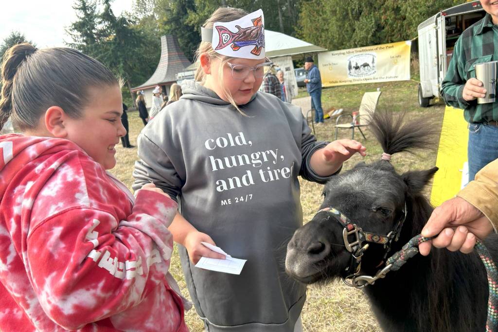 Fifth graders Chloe Corral and Marley Dockery greet Snickers the miniature horse during a visit with the Back Country Horsemen of Washington Peninsula Chapter.