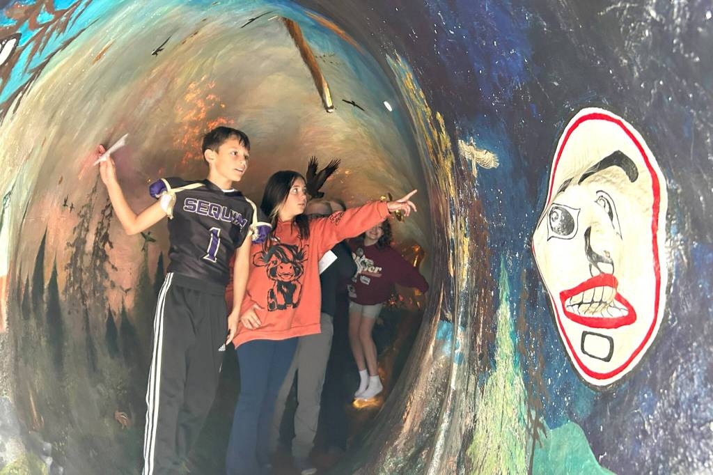 Sequim Gazette photo by Matthew Nash/ Gunner Giddings and Jillian Merrigan and fellow fifth graders climb inside Fin the Migrating Salmon courtesy of the North Olympic Salmon Coalition. The salmon model with a watershed-themed mural inside was a popular attraction at the Dungeness River Festival.