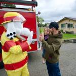 Sparky the Fire Dog gives Cedar and Josh Cooper a high five at the Clallam County Public Safety Fair in Carrie Blake Community Park where families could see and touch first responder vehicles and watch fire extinguisher demonstrations.