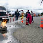 Sequim Gazette photo by Jacques Star/
Gracie Barkley learns how to use a fire extinguisher to put out a grease fire at the Public Safety Fair on Oct. 4 following advice from volunteer firefighter Thomas Danielson with Clallam County Fire District 3. Danielson said while most people own a fire extinguisher, many dont know how to use them, so its a good idea to learn how to use them properly just in case a real world situation arises.