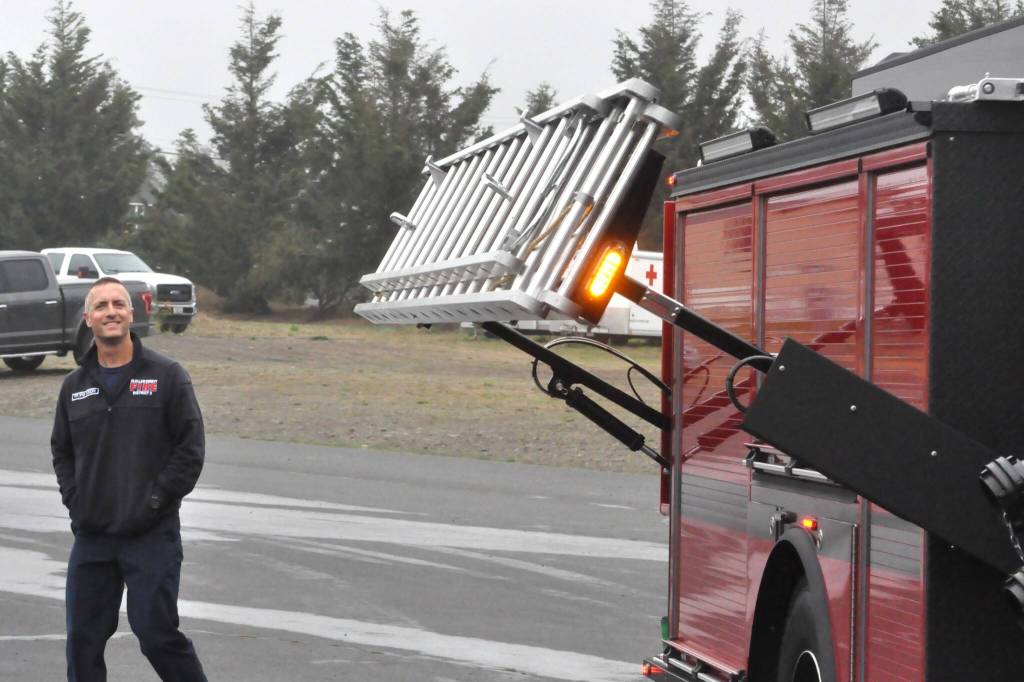 Sequim Gazette photo by Matthew Nash/
Firefighter/ Paramedic Bryant Kroh with Clallam County Fire District 3 looks at the ladder attachment on one of the districts new fire engines that arrived in recent weeks.