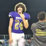 Sequim Gazette photo by Matthew Nash/ Freshman Silas Hagar smiles to the crowd as fellow freshman Kendall Adolphe accepts her sash at the Homecoming game on Oct. 3.