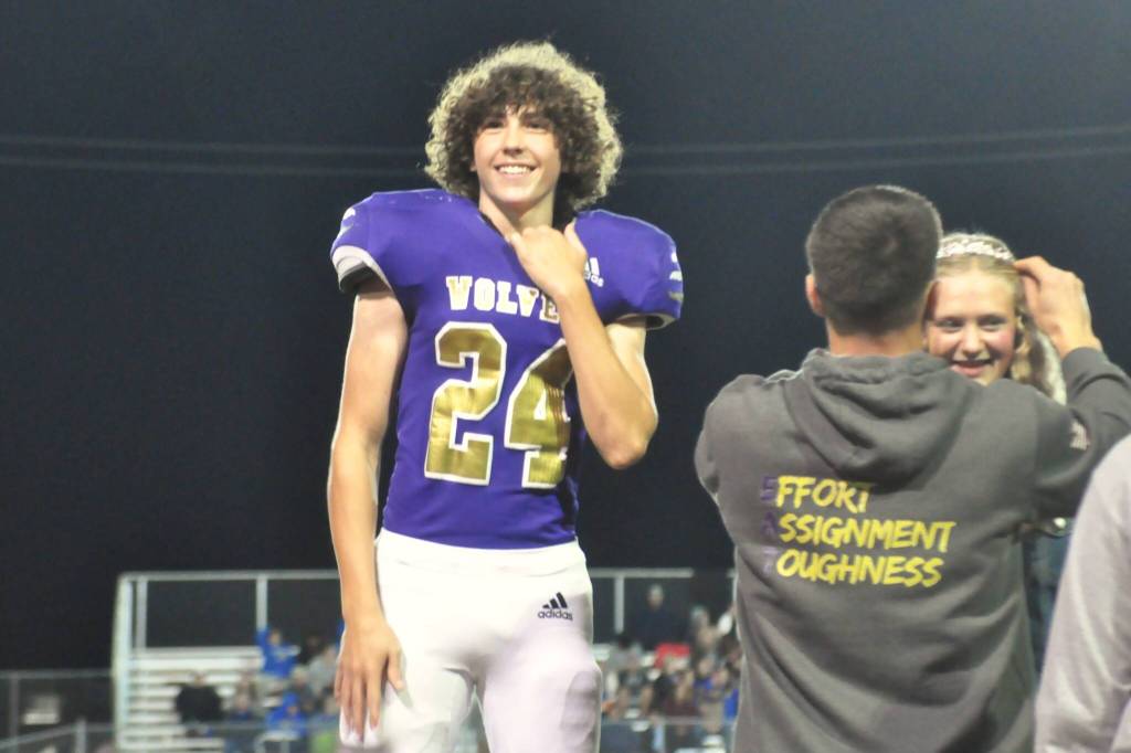 Sequim Gazette photo by Matthew Nash/ Freshman Silas Hagar smiles to the crowd as fellow freshman Kendall Adolphe accepts her sash at the Homecoming game on Oct. 3.