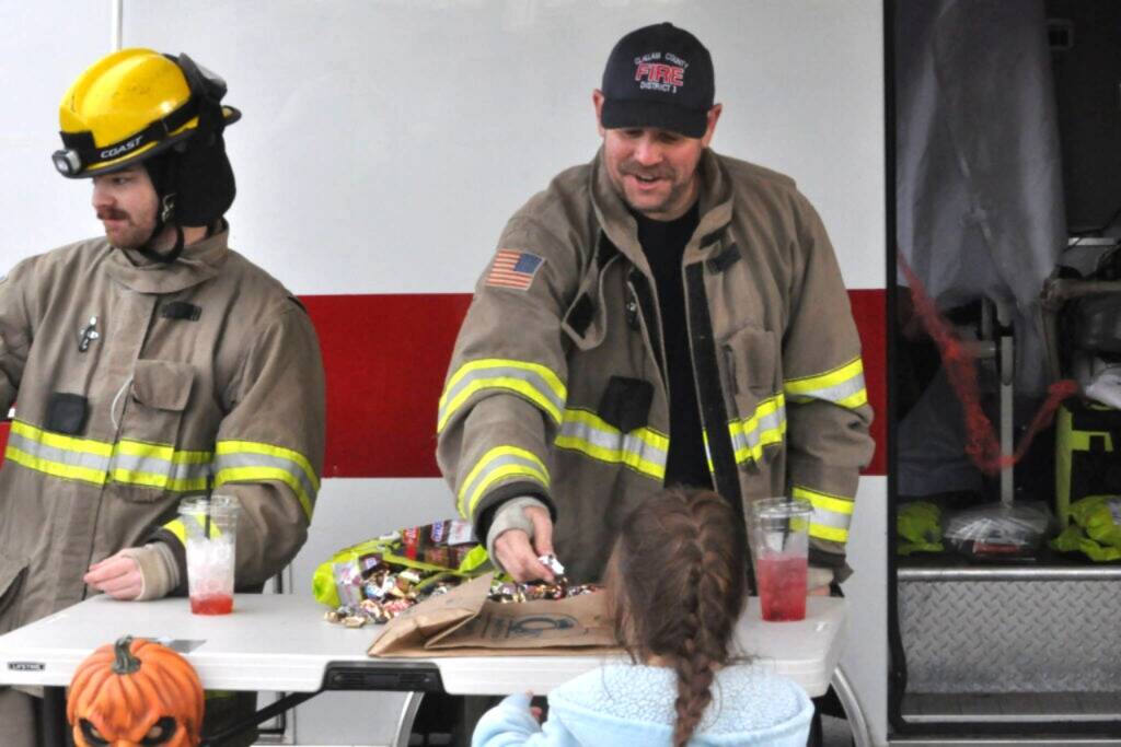 Sequim Gazette file photo by Matthew Nash/
Volunteer firefighters Tommy Danielson and Andrew Rodgers with Clallam County Fire District 3 hand out candy last year on Halloween.