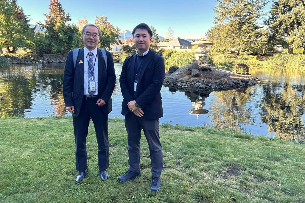 Sequim Gazette photo by Matthew Nash/
Shiso City delegates Deputy Mayor Kenji Tomita and Satoshi Ishihara with the Planning and Coordination Department stand near the lantern made by a Japanese artist from their city in 1997. It was donated and installed in the Sequim-Shiso Friendship Garden and remains a popular attraction in Carrie Blake Community Park.