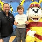 Sequim Gazette photo by 
Matthew Nash
Lucas Wright stands next to Battalion Chief Chris Turner and Sparky the Fire Dog after receiving a firefighter action figure prize and a certificate naming him honorary assistant fire chief of prevention during Fire Prevention Week, Oct. 5-11. Lucas won a coloring contest sponsored by the Sequim Gazette with Hi-Way 101 Diner and CCFD3 as partners.