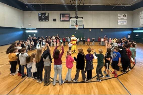 Photo courtesy Clallam County Fire District 3/
Sparky the Fire Dog stands with Lucas Wright surrounded by fellow Boys & Girls Club members to celebrate Lucas winning the Fire Prevention Week coloring contest.