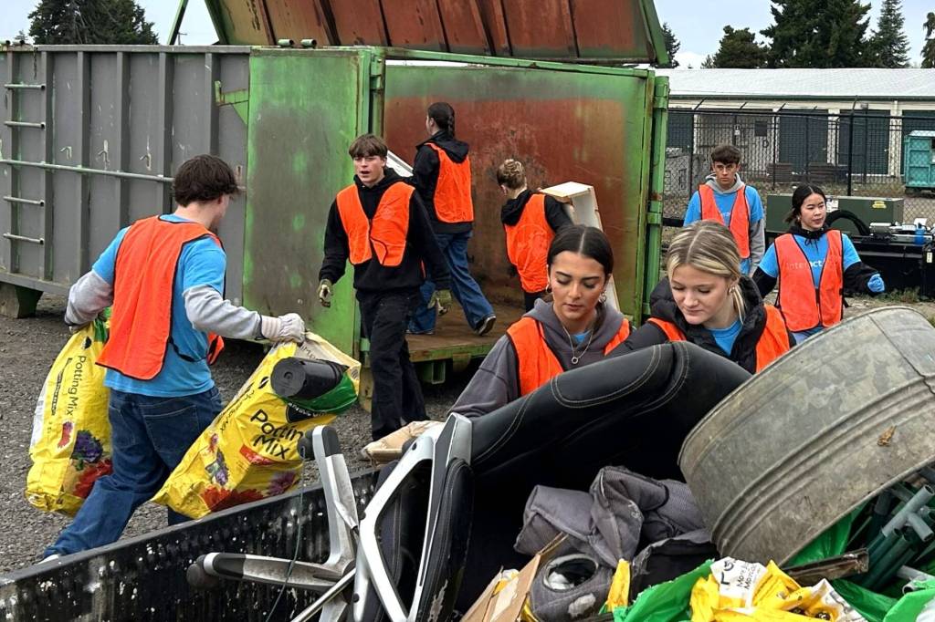 Sequim Gazette photo by Matthew Nash/
Members of the Sequim Interact Club, including seniors Willa Gradillas and Shelby Haskins, in front, help unload one of dozens of vehicles on Oct. 18 during the Rally in the Alley at the Sequim City Shop.