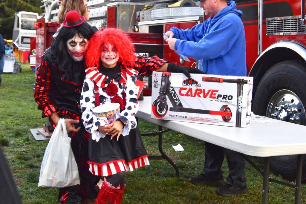 Photo by Monica Berkseth/
Dad and daughter duo Nick Romano Danielle Romano, 8, celebrate winning a scooter at the Sequim Prairie Granges Country Fair and Trunk-or-Treat for its Great Candy Drop on Oct. 25 held by Clallam County Fire District 3.
