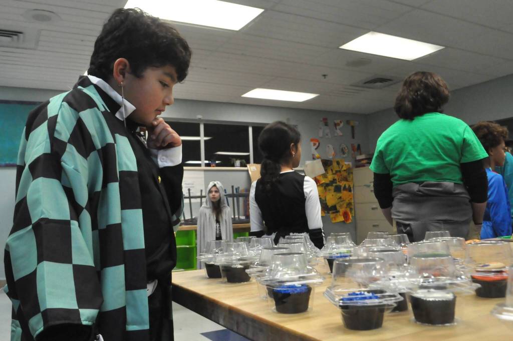 Sequim Gazette photo by Matthew Nash/
Lucca Trevino, 10, dressed as Tanjiro Kamado from Demon Slayer, carefully selects the treat he won in the Cake Walk during the Sequim Boys & Girls Clubs Halloween Bash.