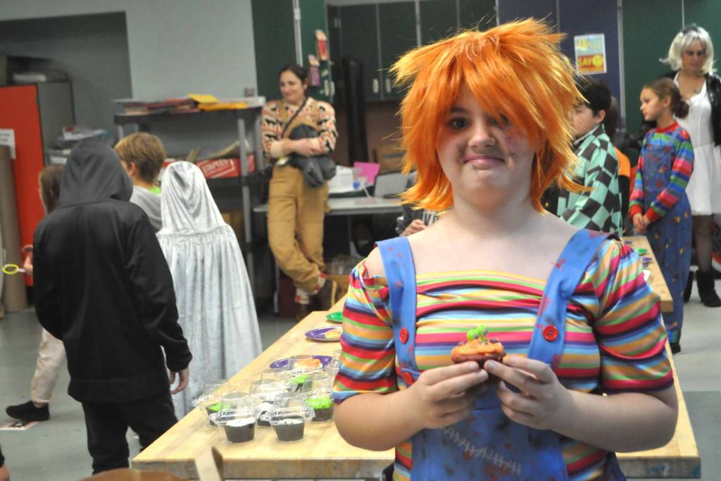 Sequim Gazette photo by Matthew Nash/
Mackenzie Erks, 10, dressed as Chucky from Childs Play, shows the cupcake she won during the Cake Walk at the Halloween Bash inside the Boys & Girls Club.