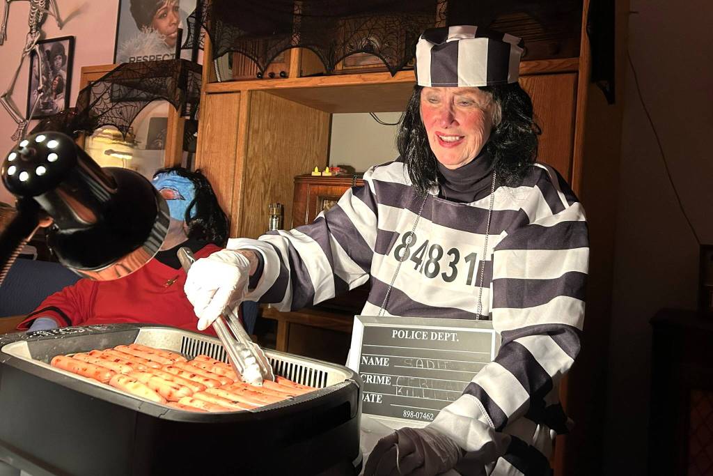 Sequim Gazette photo by Matthew Nash/
Sue Pechina, a volunteer for KSQM 91.5 FM, grills hot dogs for the radio stations Halloween event.